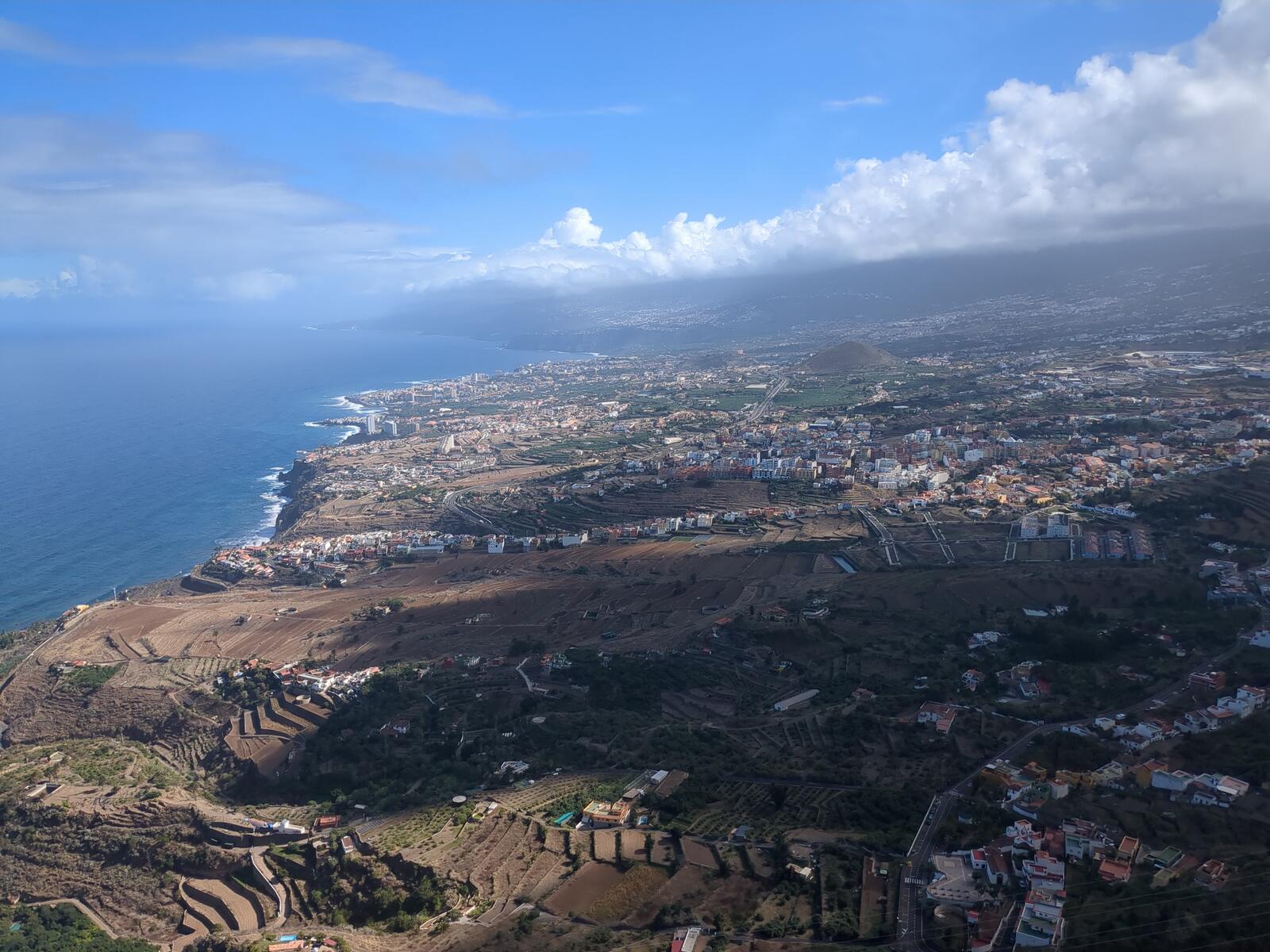 Blick von oben auf die Nordküste Teneriffas mit Küstenorten, Terrassenfeldern und dem Atlantik